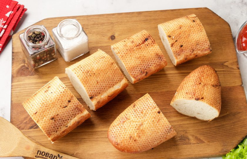 1. Этап. Праздничные бутерброды Змейка: Разрежьте багет на части, в зависимости от желаемого размера бутербродов.