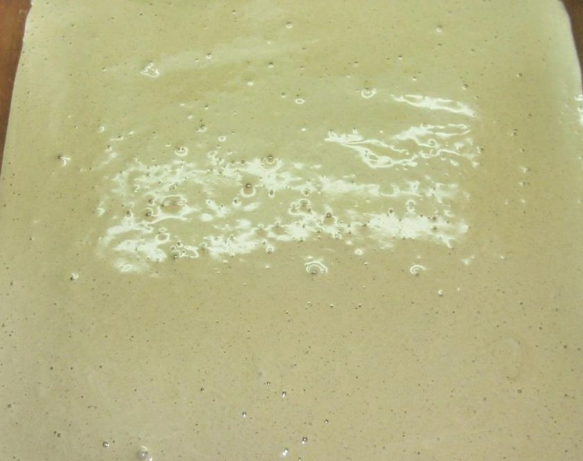 1. Этап. Тирамису Вива Италия: 6. Застилаем противень пергаментом и начиная с середины выливаем на него тесто. Равномерно распределяем тесто по всей поверхности и отправляем в разогретую до 200 градусов духовку на 10 минут.