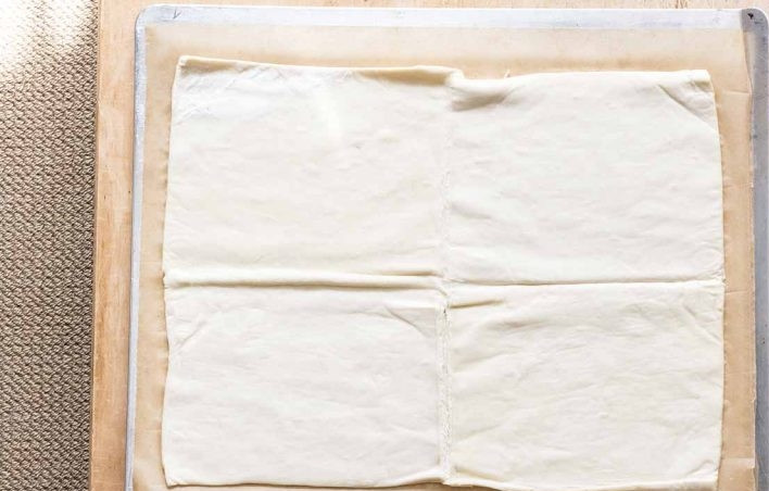 1. Этап. Картофельный тарт: 1. Разверните слоеное тесто и заранее его разморозьте. Выложите тесто на пергамент и раскатайте его тонко, но не слишком.