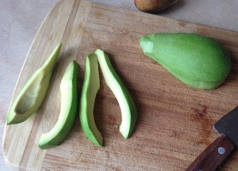 1. Этап. Авокадо во фритюре: В первую очередь ставим на плиту небольшую сковороду с маслом, пусть нагревается. Авокадо очистим и разрежем пополам, извлечем косточку. Нарежем половинки авокадо на дольки.