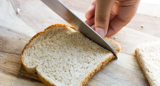 1. Этап. Рулетики с колбасой и сыром: 1. С ломтиков тостового хлеба (в рецепт приготовления рулетиков с колбасой и сыром лучше всего использовать именно его) аккуратно срезать острым ножом корочку.