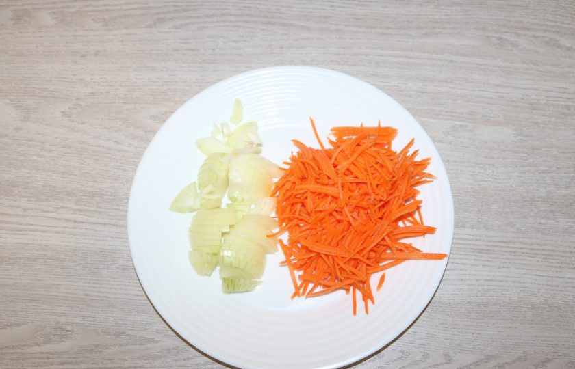 1. Этап. Хе из сельди по-корейски: Морковь натрите на тёрке по-корейски. Лук нарежьте полукольцами.