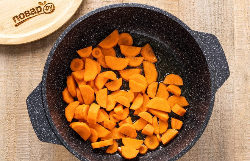 1. Этап. Баклажаны 5 овощей на зиму: Морковь помойте, очистите от кожуры и нарежьте ломтиками среднего размера. Обжарьте ее в растительном масле пару минут на среднем огне.