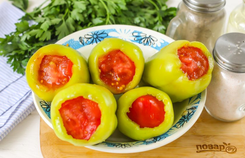 1. Этап. Долма из перцев: Промойте помидоры и вырежьте сердцевинки из них. Нарежьте один из них кружочками и закройте отверстия в перцах, чтобы фарш не выпал при варке.