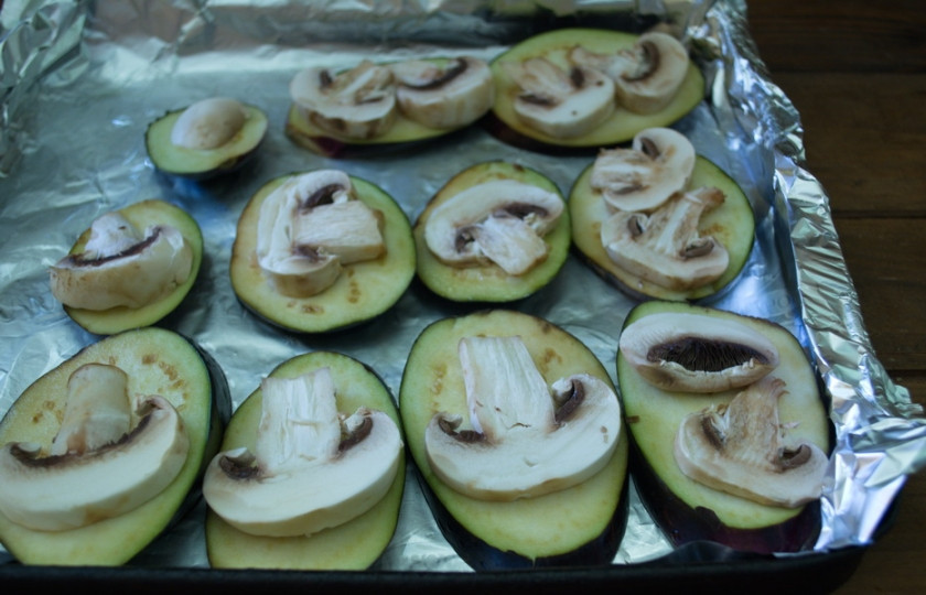 1. Этап. Баклажаны, запеченные с помидорами и сыром: На каждое кольцо баклажана уложите по кусочку шампиньона.