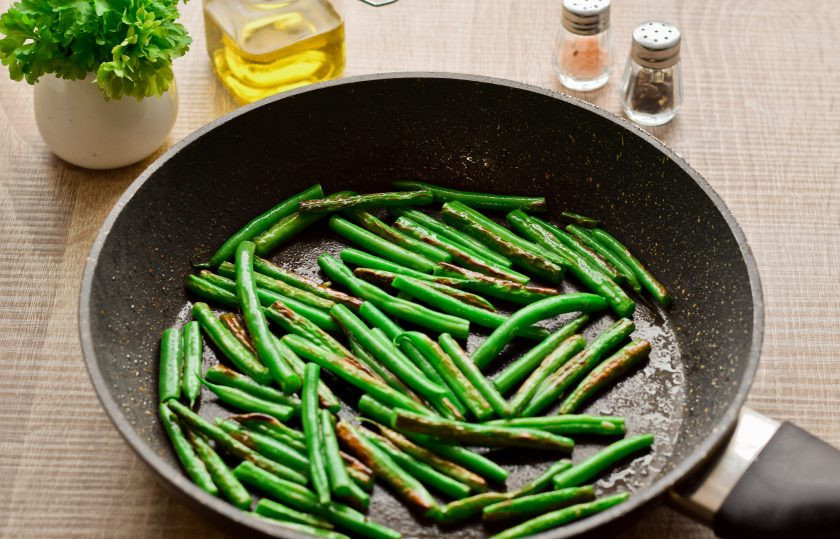 1. Этап. Спаржевая фасоль в яйце с сыром: В разогретую сковороду влейте немного масла, выложите фасоль и жарьте 4-5 минут на небольшом огне, под крышкой.