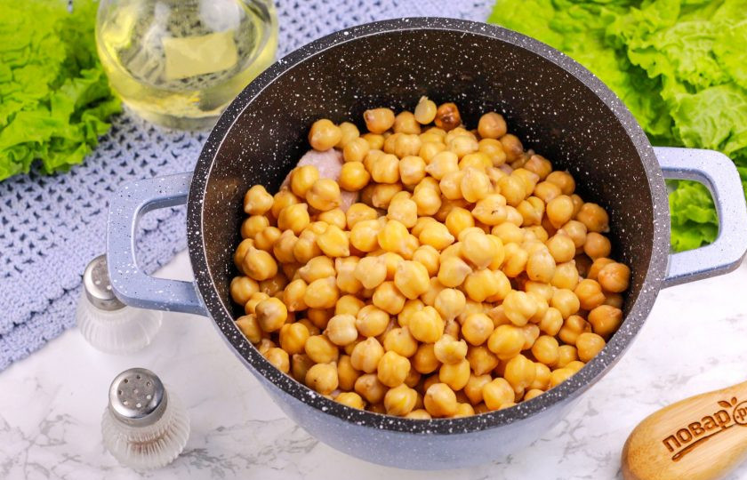 1. Этап. Рис с нутом и мясом: Всыпьте нут в казан и перемешайте. Обжарьте 4-5 минут, перемешивая.