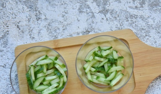 1. Этап. Салат с рисом и тунцом: В порционные бокалы укладываю огуречную соломку. Слегка придавливаю ко дну с помощью ложки.