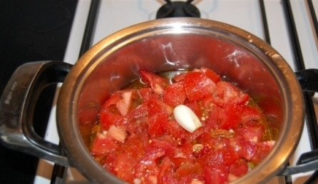 1. Этап. Осьминог по-итальянски: Отправляем осьминога головой вниз в кастрюлю. Помытые помидоры нарезаем на небольшие кусочки, перец чили режем мелко. Их тоже отправляем в кастрюлю, добавляем оливковое масло и зубчик чеснока.