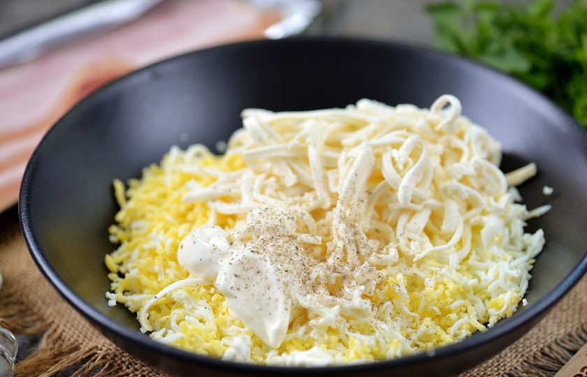 1. Этап. Рулетики из бекона с сыром и яйцом: Добавьте майонез, соль и перец по вкусу. При желании в начинку можно положить измельченный чеснок, если любите его вкус и аромат. Тщательно перемешайте начинку до однородного состояния.