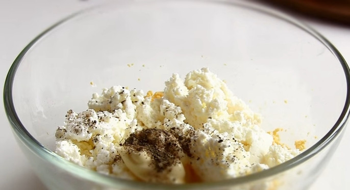 1. Этап. Простая закуска из сельди: 2. Добавьте к желткам творог, майонез, черный молотый перец. Перемешайте.