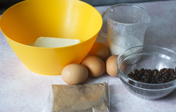 1. Этап. Черемуховый кекс: 1. Яйца и масло заранее достаньте из холодильника. Изюм промойте, затем выложите в миску и влейте коньяк, оставьте на 15 минут. Просейте пшеничную муку.