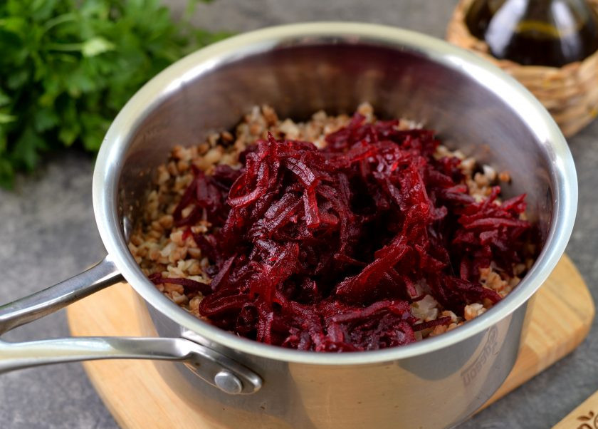 1. Этап. Красная гречка: Свеклу почистите от кожуры, натрите на терке, переложите в сотейник с гречневой кашей, посолите и поперчите по вкусу.