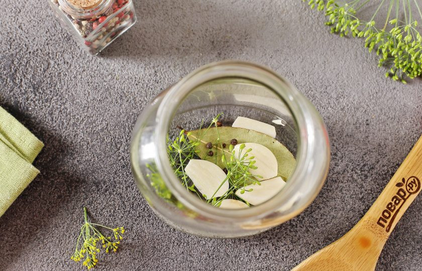 1. Этап. Ассорти из помидоров и кабачков на зиму: В чистые стерилизованные банки выложите на дно укроп, перец и лаврушку.