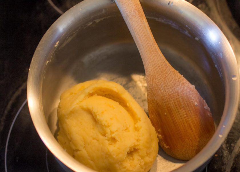 1. Этап. Профитроли с творожным кремом: Добавьте муку и взбивайте. Тесто должно собраться в шар и легко отделяться от стенок кастрюли.