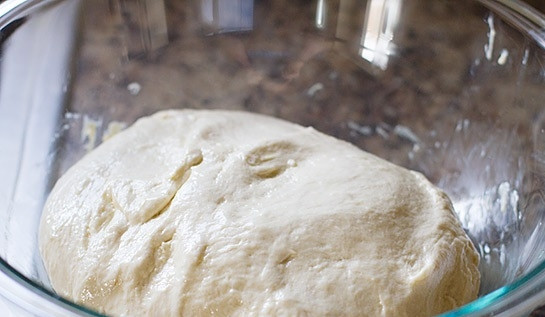 1. Этап. Тесто для пиццы с сухими дрожжами: 4. Возьмите большую миску или кастрюлю, налейте в нее растительное масло, смажьте им стенки. Переложите тесто из чаши в миску.