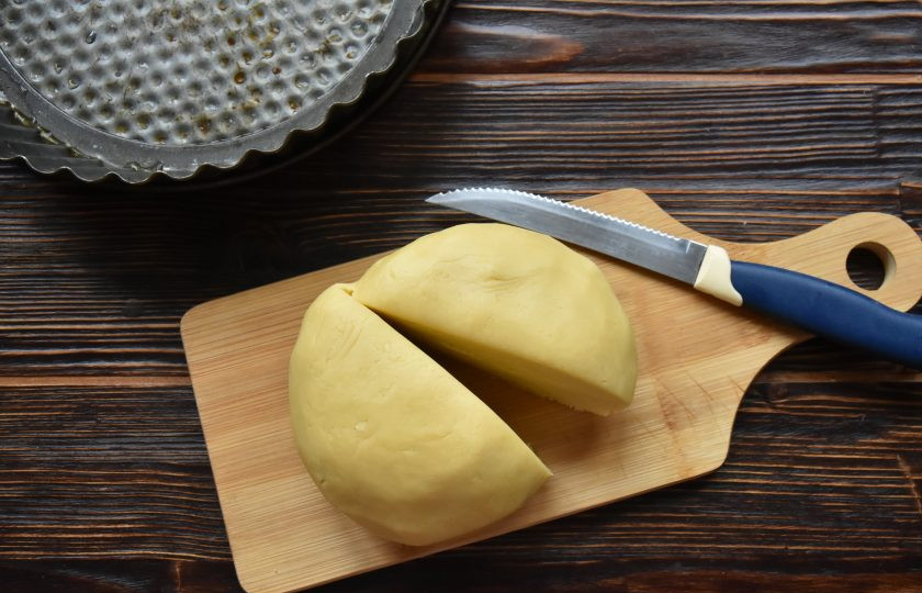 1. Этап. Пирог Ложный сырник: Разделите тесто на две части. Каждую оберните пищевой пленкой и положите охлаждаться в холодильник.