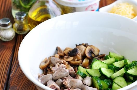 1. Этап. Салат из куриных сердечек с грибами и сыром: 4. Добавьте нарезанный ломтиками огурчик.