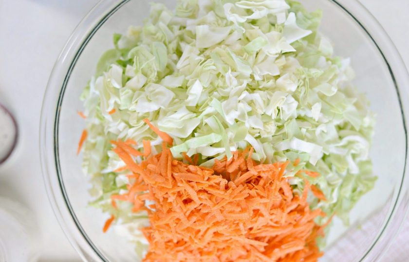 1. Этап. Капустный салат с заправкой: Для начала мелко нашинкуйте капусту, а морковь натрите на крупной тёрке. Переложите овощи в салатницу.