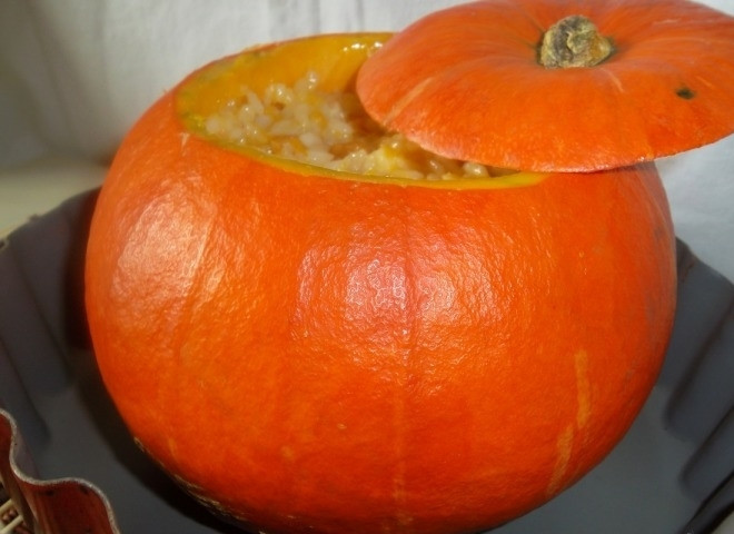 1. Этап. Фаршированная тыква, запеченная в духовке с рисом: Переложите все в горшочек из тыквы. Накройте крышкой. Тыкву поставьте в форму для запекания и поместите в разогретую до 200 градусов духовку на полтора часа.