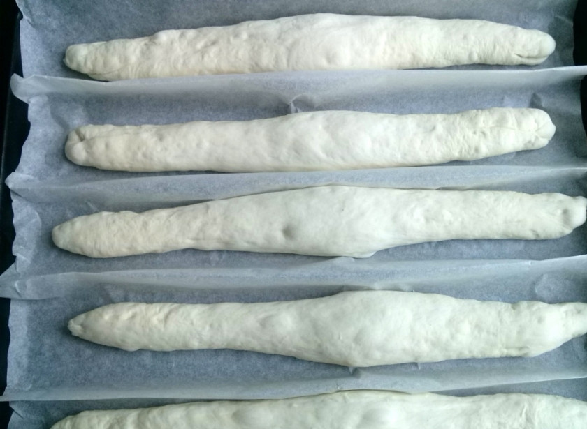 1. Этап. Багет классический: Возьмите пергамент, сделайте на нем складки, выложите заготовки, присыпьте их мукой, накройте и оставьте для подъема на 30 минут.