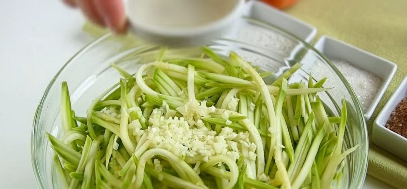 1. Этап. Салат из кабачков по-корейски: 1. Кабачки промойте, натрите на мелкой специальной терке или нарежьте тонкой длинной соломкой. Чеснок измельчите и добавьте к кабачкам.