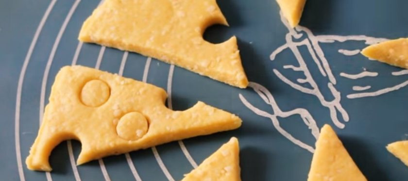 1. Этап. Простые сырные крекеры: 3. Вырежьте из него круг и нарежьте его треугольниками. В каждом треугольнике вырежьте небольшие круглые отверстия, чтобы они стали похожи на кусочки сыра.