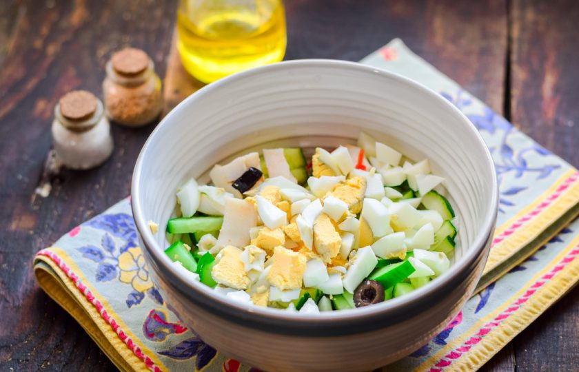 1. Этап. Салат из вешенок и кальмаров: Куриное яйцо отварите и нарежьте небольшими кубиками, добавьте в салат.