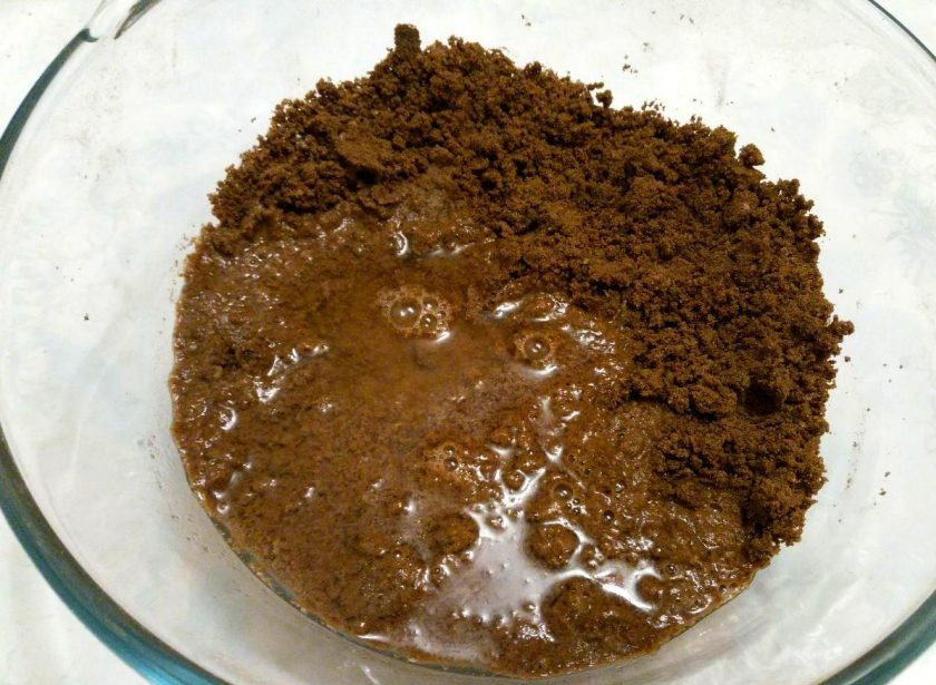 1. Этап. Шоколадный пирог с гречневой мукой: Небольшими порциями влейте воду в получившуюся крошку, замешивая тесто при помощи ложки или лопатки.