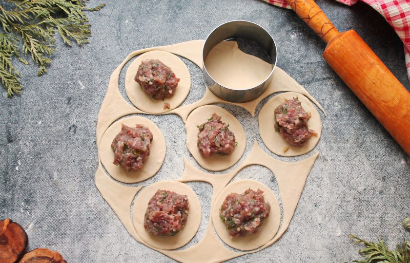 1. Этап. Манты из лосятины: Рабочую поверхность слегка посыпьте мукой и раскатайте тесто в тонкий пласт и вырежьте кружочки. Удобно это сделать небольшим кулинарным кольцом. Положите в середину часть фарша.