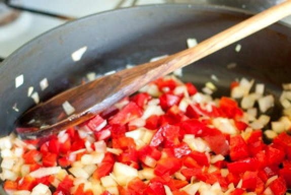 1. Этап. Гарнир из перловки: А пока приступим к приготовлению овощей. Мелко порубим репчатый лук, нарежем помидорку и перчик. Разогреем сковородку, нальем в нее подсолнечное масло. Овощи обжарим с добавлением соли и специй по вкусу.