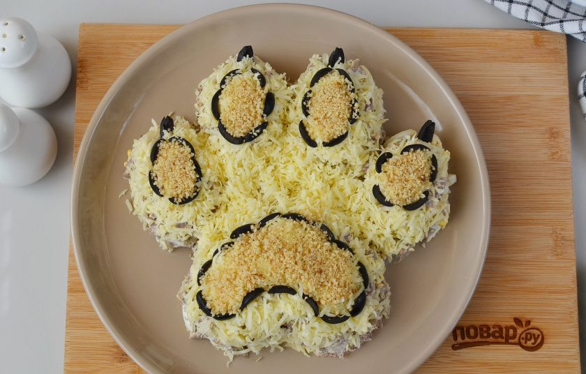 1. Этап. Салат Лапа тигра: Сделайте из порезанных маслин контуры подушечек, когти. Внутрь выложите немного молотых грецких орехов. Лапа тигра готова!