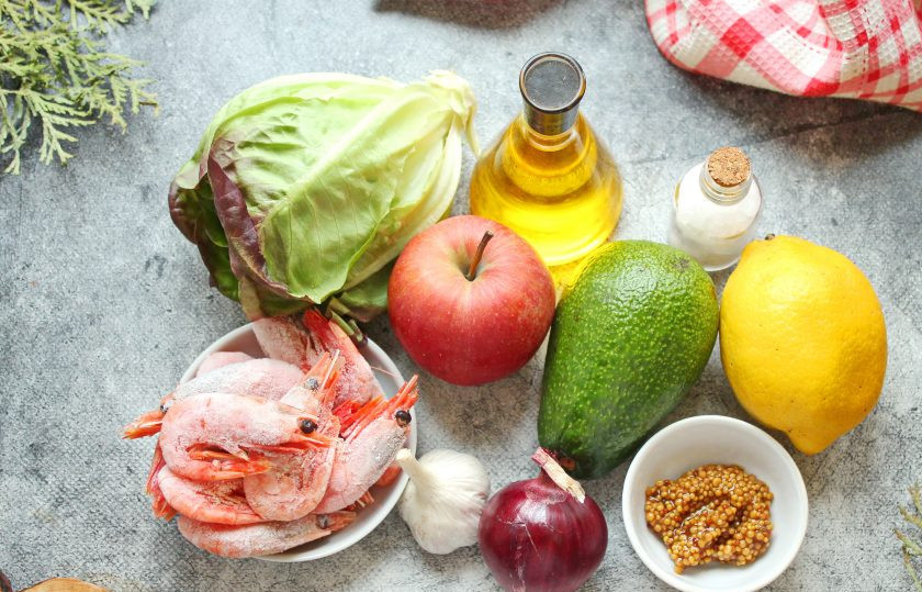 1. Этап. Салат с креветками и авокадо и яблоком: Подготовьте все необходимые ингредиенты для приготовления салата с креветками и авокадо и яблоком. Яблоко, авокадо и листья салата вымойте и обсушите. Красный лук и чеснок почистите. Креветки разморозьте, почистите и залейте кипятком на 1-2 минуты, затем откиньте на сито.