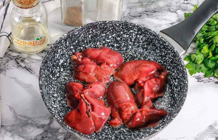 1. Этап. Салат с куриной печенью и кинзой: Прогрейте в сковороде растительное масло и выложите в него обсушенную куриную печень. Обжарьте с каждой стороны по 3-5 минут до румяности, не соля блюдо. Обязательно накройте сковороду крышкой, так как печень 