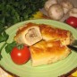 Блины с пшеничной крупой и грибами Яйца слегка взбить, постепенно всыпать просеянную муку. Влить молоко, растительное масло, добавить соль. Хорошо перемешать венчиком и оставить на 15 минут. Испечь блины в хорошо нагретой и смазанной маслом чугунной сковороде до румяности. Шампиньоны и лук мелко нарезать. В сковороде с разогретым растительным и сливочным маслом спассеровать лук до легкой золотистости, добавить грибы - обжарить до готовности. Пшеничную крупу отварить в подсоленной воде и смешать с грибами. Порцию начинки выложить на блинчик и завернуть трубочкой. В форму для запекания переложить начиненные блинчики. Залить сливками и посыпать тертым сыром. Запечь в духовке при 180 градусах до подрумянивания сыра.