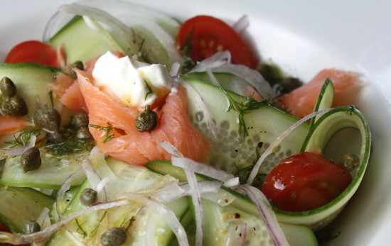 1. Этап. Салат с семгой и огурцом: 2. Приготовленные овощи выложите в миску. Укроп понадобится для соуса. Семгу нарежьте или порвите тонкими полосками, добавьте в миску вместе с каперсами. Приготовьте соус, смешав в мисочке горчицу, уксус и масло, добавьте соль, перец, укроп, еще раз перемешайте. Выложите салат на порционные тарелки. Выложите на каждую порцию немного сметаны.