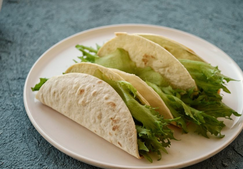 1. Этап. Тако с фасолью: Теперь соберите тако: в пшеничные лепешки вложите листья салата, потом начинку из фасоли. Сверху полейте соусом.