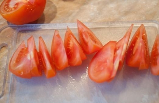 1. Этап. Салат из кальмара и креветок: 3. Небольшими ломтиками нарежьте помидорчик.