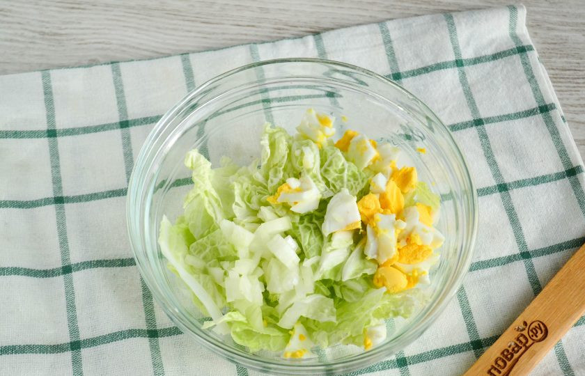 1. Этап. Салат с пекинской капустой и сайрой: Яйца порежьте среднего размера кусочками. А вот лук нарежьте мелко. Впрочем, его можно нарезать полукольцами и замариновать.