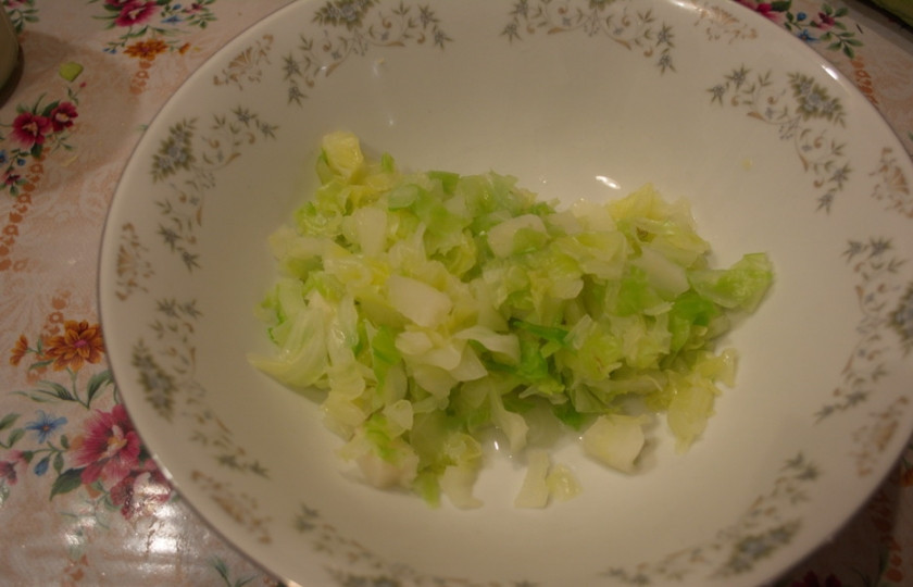 1. Этап. Капустные оладьи на кефире: Капусту белокочанную нашинковать мелко. Поместить в кастрюлю, влить 1 стакан воды и дать закипеть. Помешивая, варите капусту в слегка подсоленной воде 6-7 минут. Откиньте на сито. Дайте стечь воде. Капусту поместите в миску.
