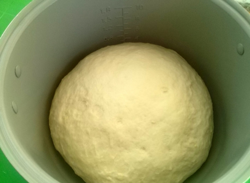 1. Этап. Сдобная плетенка с яблоками: Через час тесто прекрасно подошло. Разделите его на две равные части. Одну часть раскатайте в прямоугольник размером 20х35см. и выложите его на пергамент.