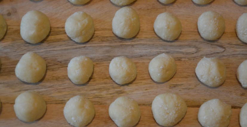 1. Этап. Пончики из детства: Из полученного теста сформируйте заготовки для пончиков. Для этого отщипывайте от теста кусочки и скатывайте шарики, которые по размеру не должны быть больше, чем грецкий орех.