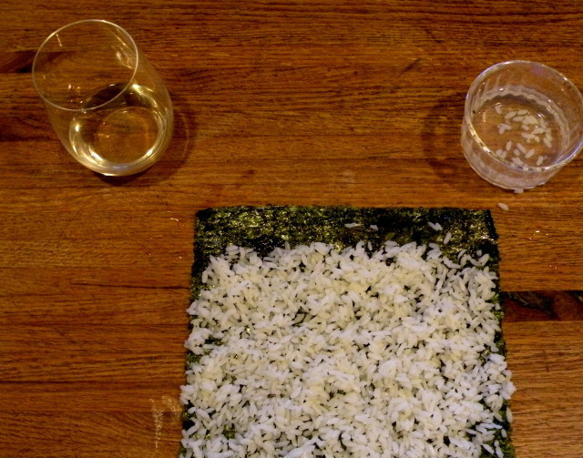 1. Этап. Постные роллы: 2. Распределите рис по листу нори тонким слоем. Оставьте один край (сантиметр) чистым.