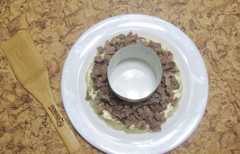 1. Этап. Салат Гранатовый браслет с языком: Отварной язык нарежьте кубиками и выложите вторым слоем салата. Поперчите и смажьте майонезом.