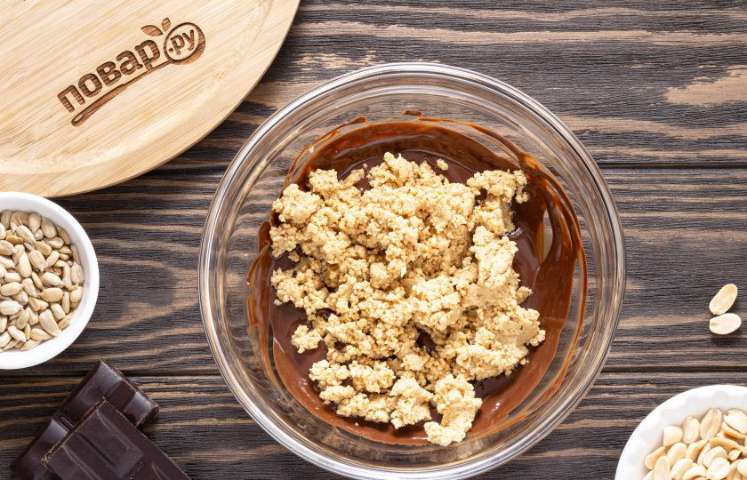 1. Этап. Шоколадная халва: Затем постепенно начните добавлять измельченные семечки с арахисом.