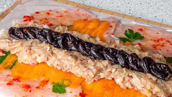 1. Этап. Праздничный куриный рулет: 6. На рабочую поверхность выложите куриные грудки кожицей вниз. Сверху ломтики тонко нарезанной моркови. Можно добавить еще немного зелени. Затем фарш и чернослив.
