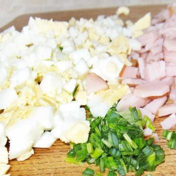 1. Этап. Блины с ветчиной: 4. Измельчить ветчину, вареные яйца и лук. Выложить в миску и перемешать с майонезом. Выложить полученную начинку на середину каждого блина.