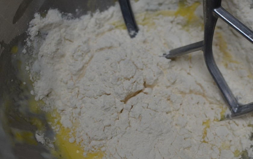 1. Этап. Вареники с ягодами: Сначала подготовим начинку. Для этого ягоду промоем, просушим бумажным полотенцем, сложим в миску, посыплем сахаром и отставим в сторону. Затем готовим тесто. Для этого при помощи миксера или кухонного комбайна взобьем вместе яйца со сметаной, добавим один стакан муки, соль и сахар.