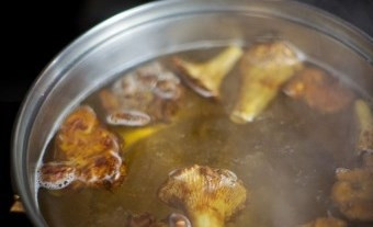 1. Этап. Мясо с лисичками: Кастрюлю ставим на средний огонь, воду солим, доводим до кипения, затем убавляем огонь и томим лисички в течение 45 минут.