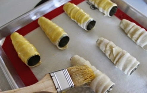 1. Этап. Трубочки с изюминкой: 6. Выложите все трубочки на противень и смажьте оставшимся куриным желтком.